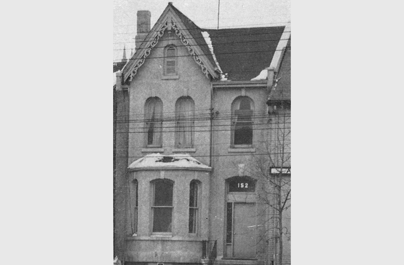 Historic residential building with a steep gabled roof, arched windows, and a covered front entry, used as transitional housing in the 1990s.