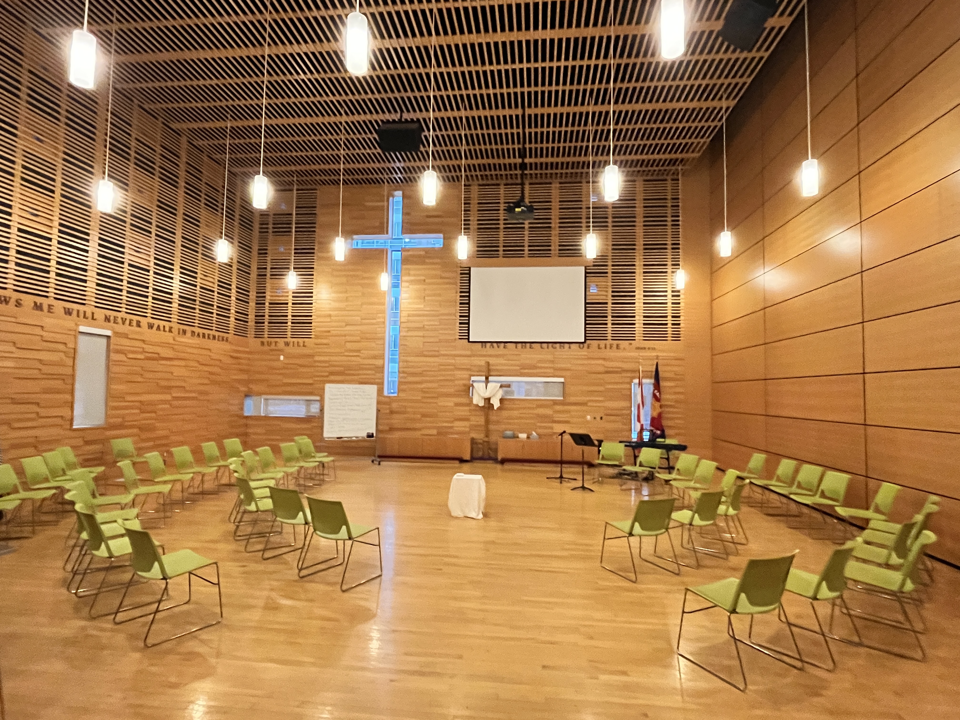 Worship space at Downtown East Community Church with chairs arranged in a semi‑circle facing a platform with an illuminated cross.